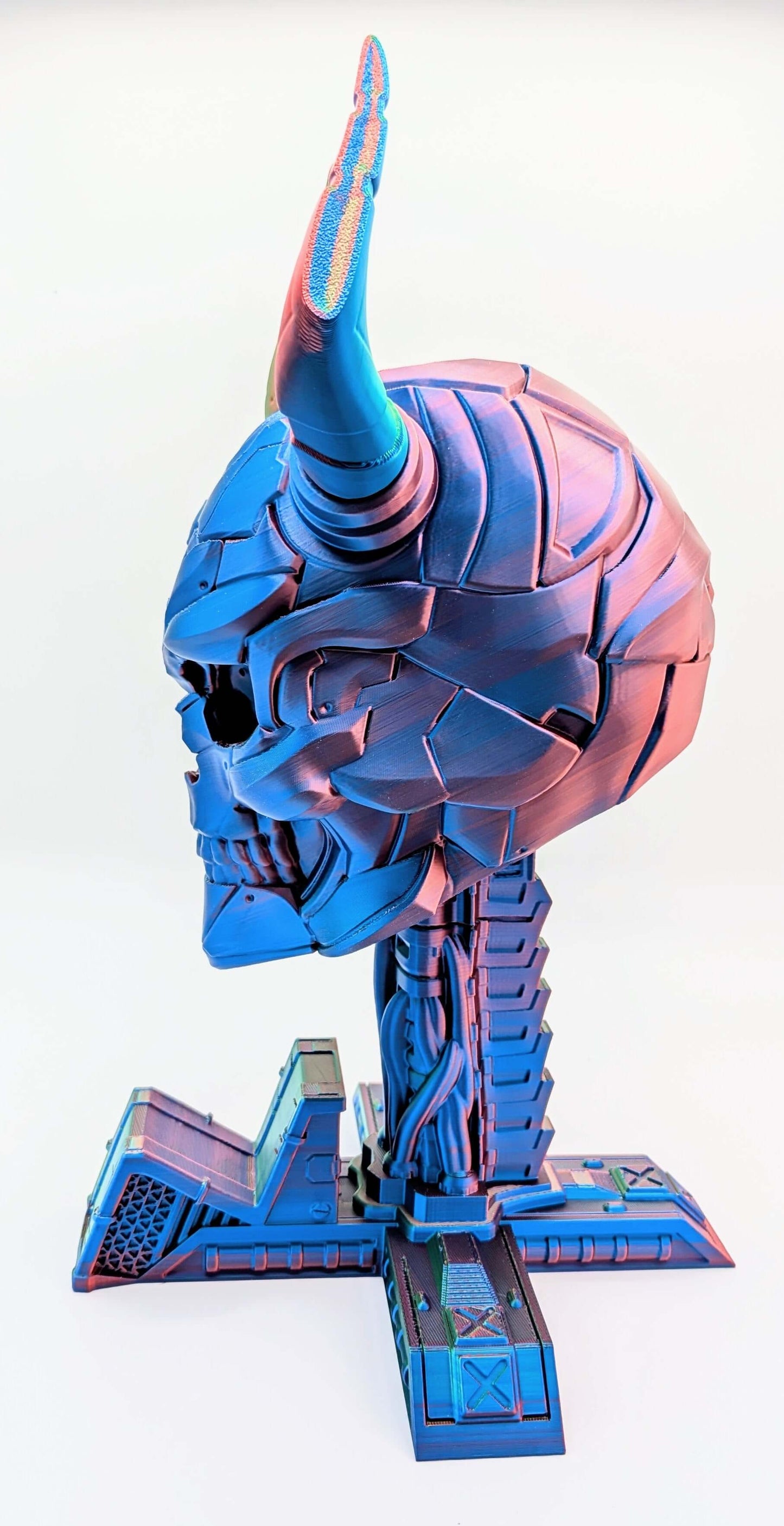 Colorful demon skull headphone and game controller display, featuring intricate detailing and striking blue and pink hues.